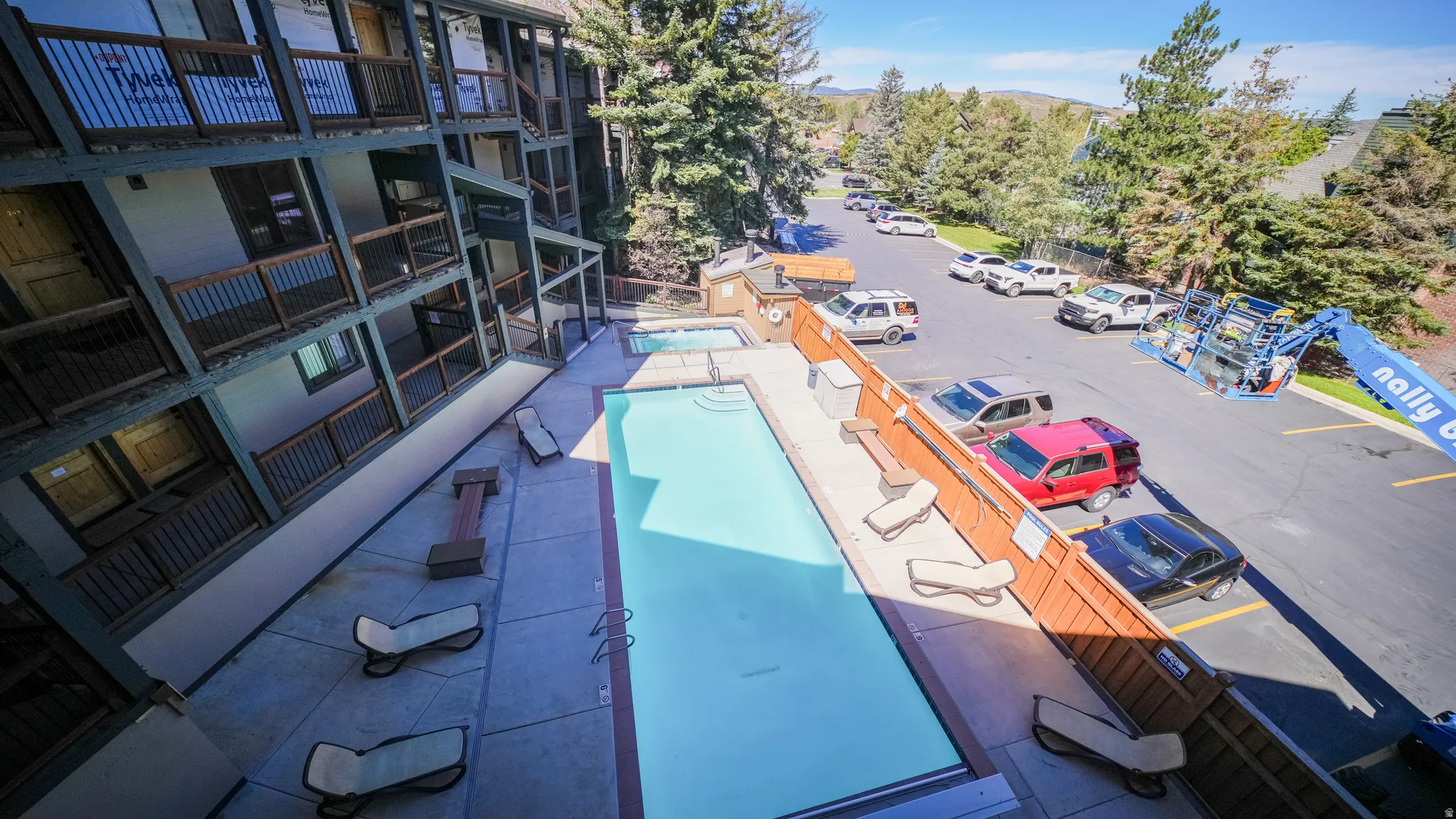 Community swimming pool with an adjacent hot tub and surrounding patio