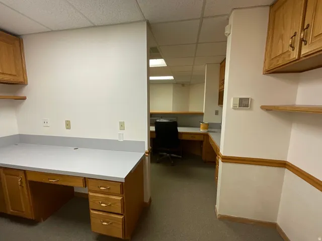 Built-in office cabinetry with light wood-finish and matte gray countertops