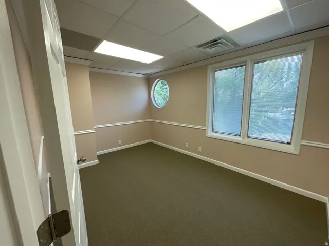 Wall-to-wall carpeting, multiple windows, built-in ceiling lighting, and crown molding
