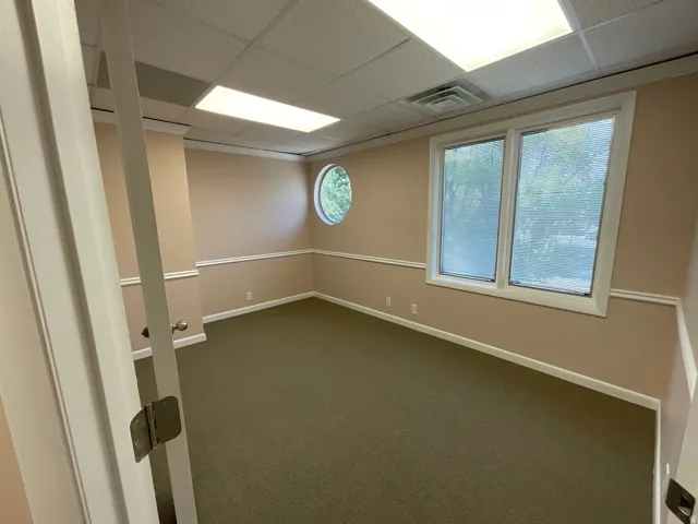 Recessed lighting, drop ceiling, wall trim, carpet flooring, and multiple windows