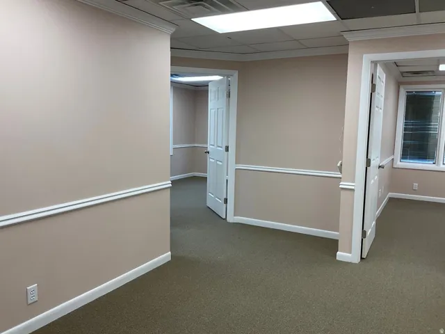 Neutral-toned walls with chair rail molding and crown molding