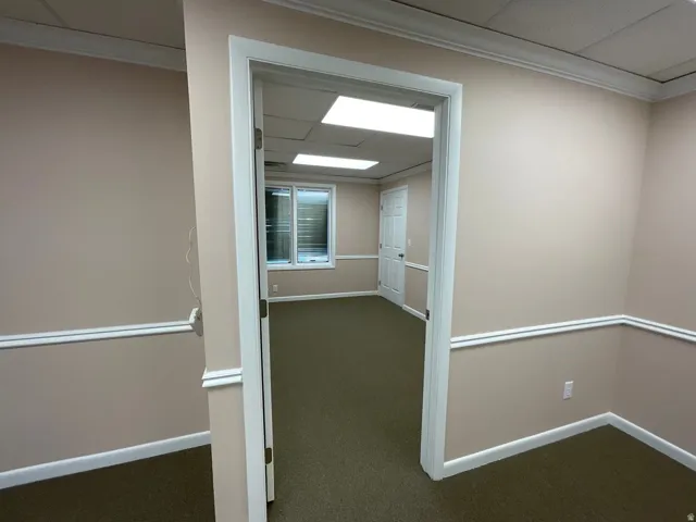 Warm-toned wall paint, decorative chair rail molding, crown molding, and recessed lighting