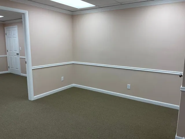 Neutral-toned walls with chair rail molding and crown molding