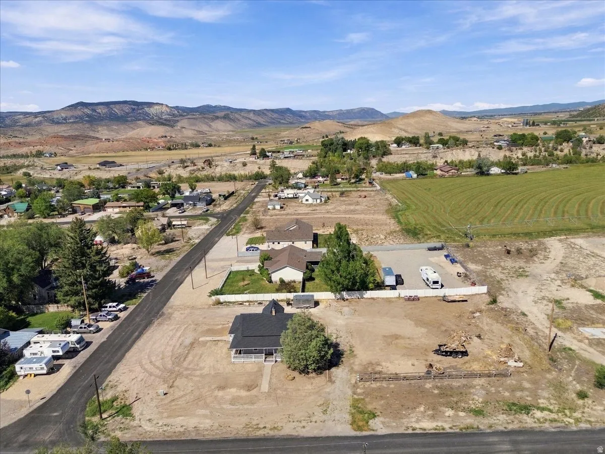 Expansive lot featuring a single-story residence with a covered front porch, surrounded by open land and distant mountains