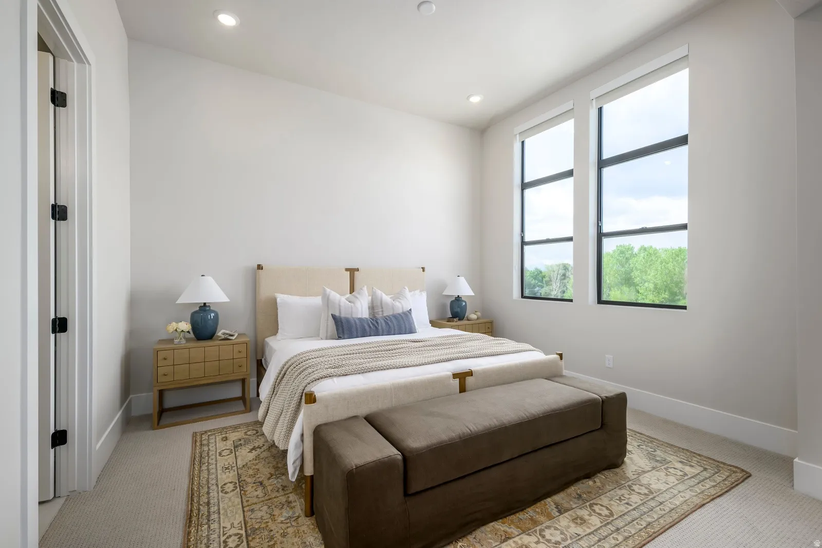Recessed lighting, light-toned carpeting, high ceilings, full-height windows, and wide baseboards