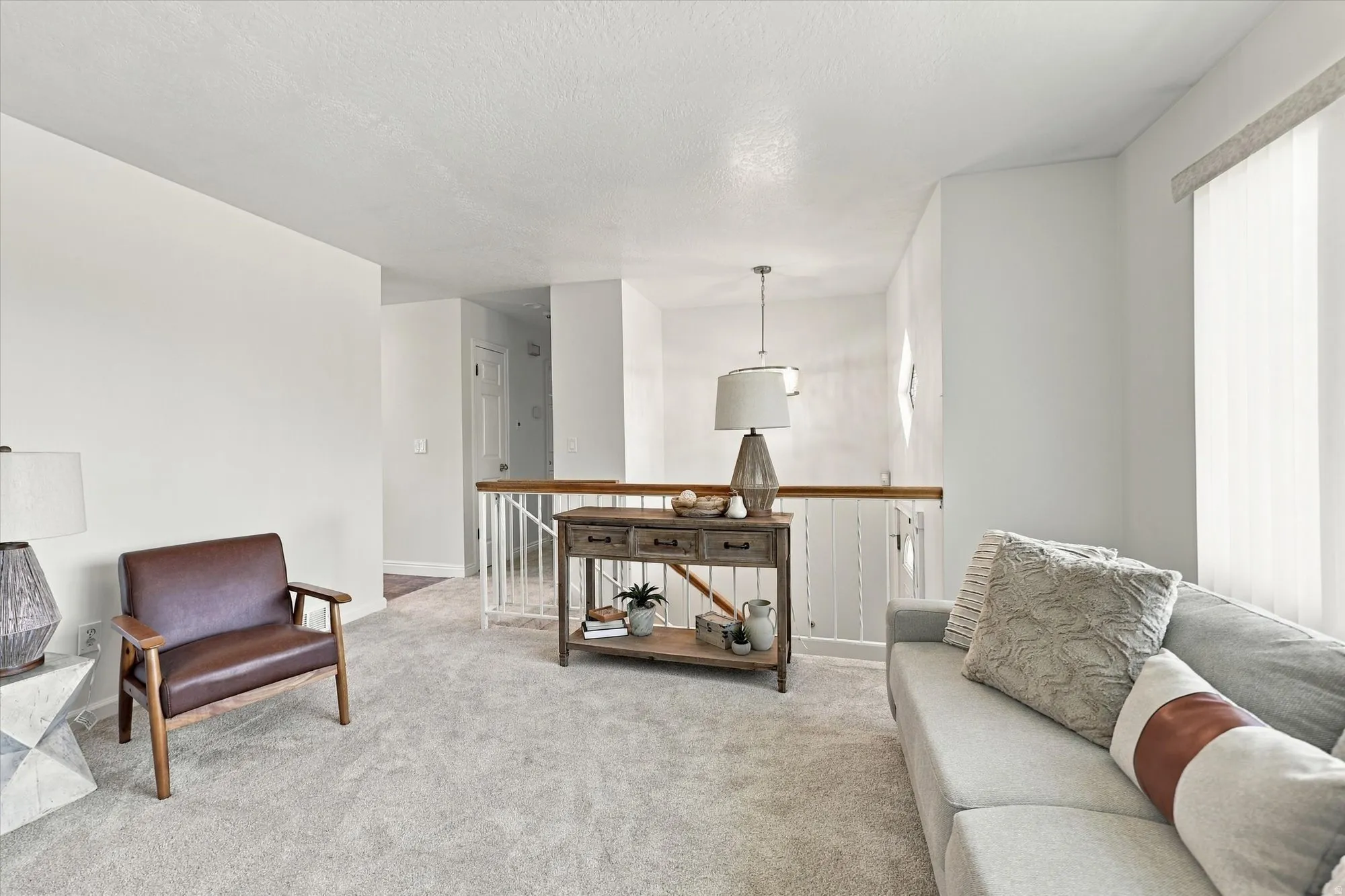 Neutral wall finishes, light carpeting, window treatments, and a wood-finish handrail
