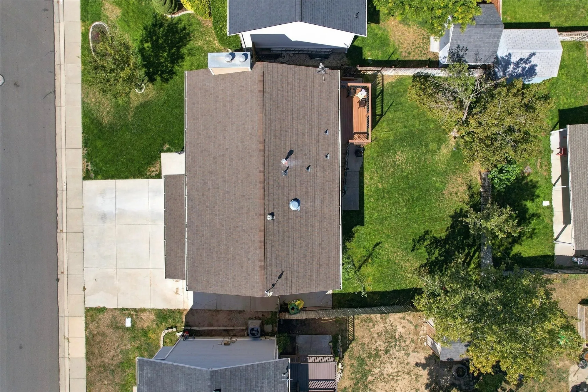 Asphalt shingle roofing, concrete driveway, front yard lawn, backyard lawn, wooden deck