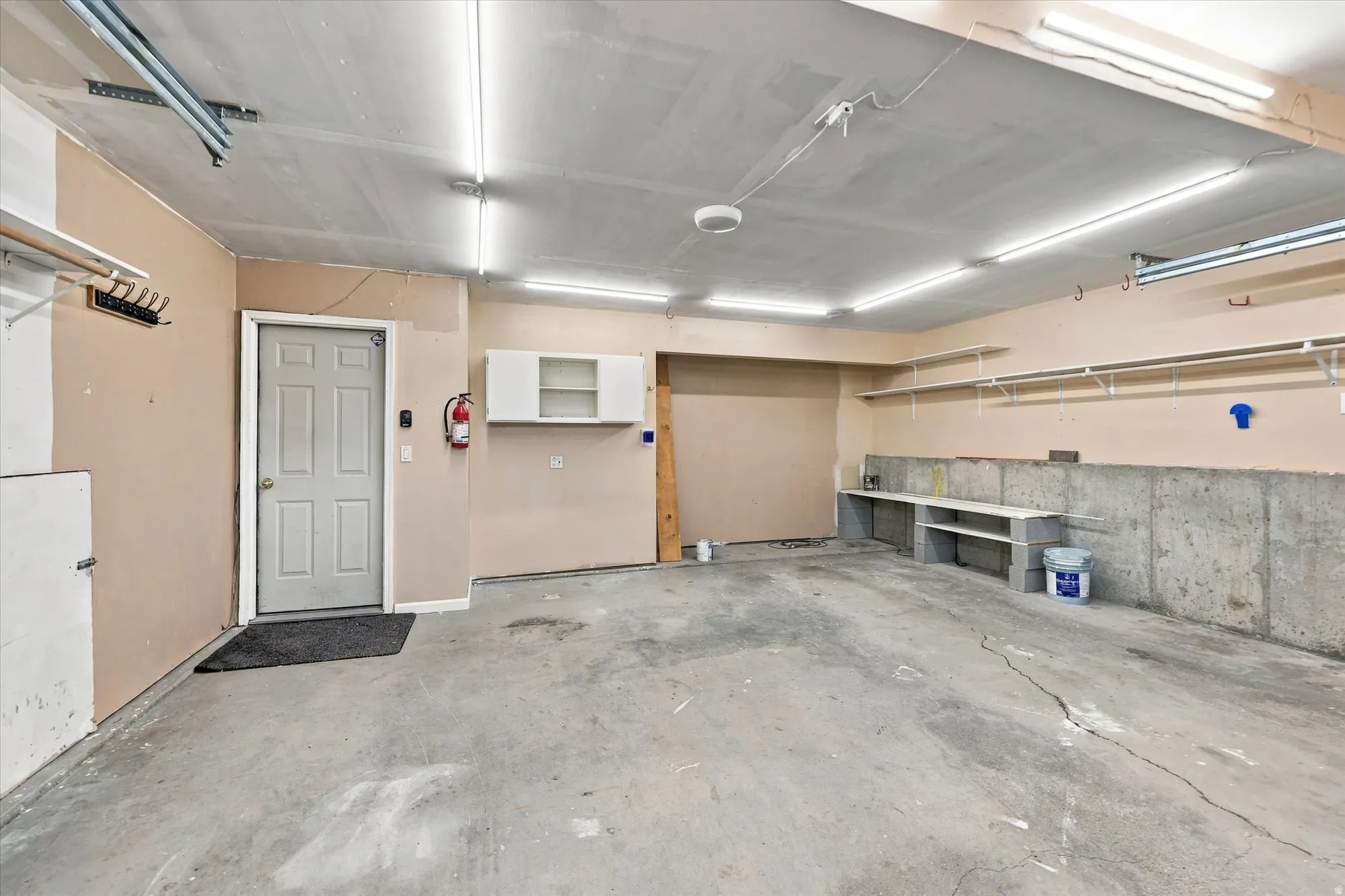 Concrete flooring, built-in shelving, overhead lighting, and built-in cabinetry