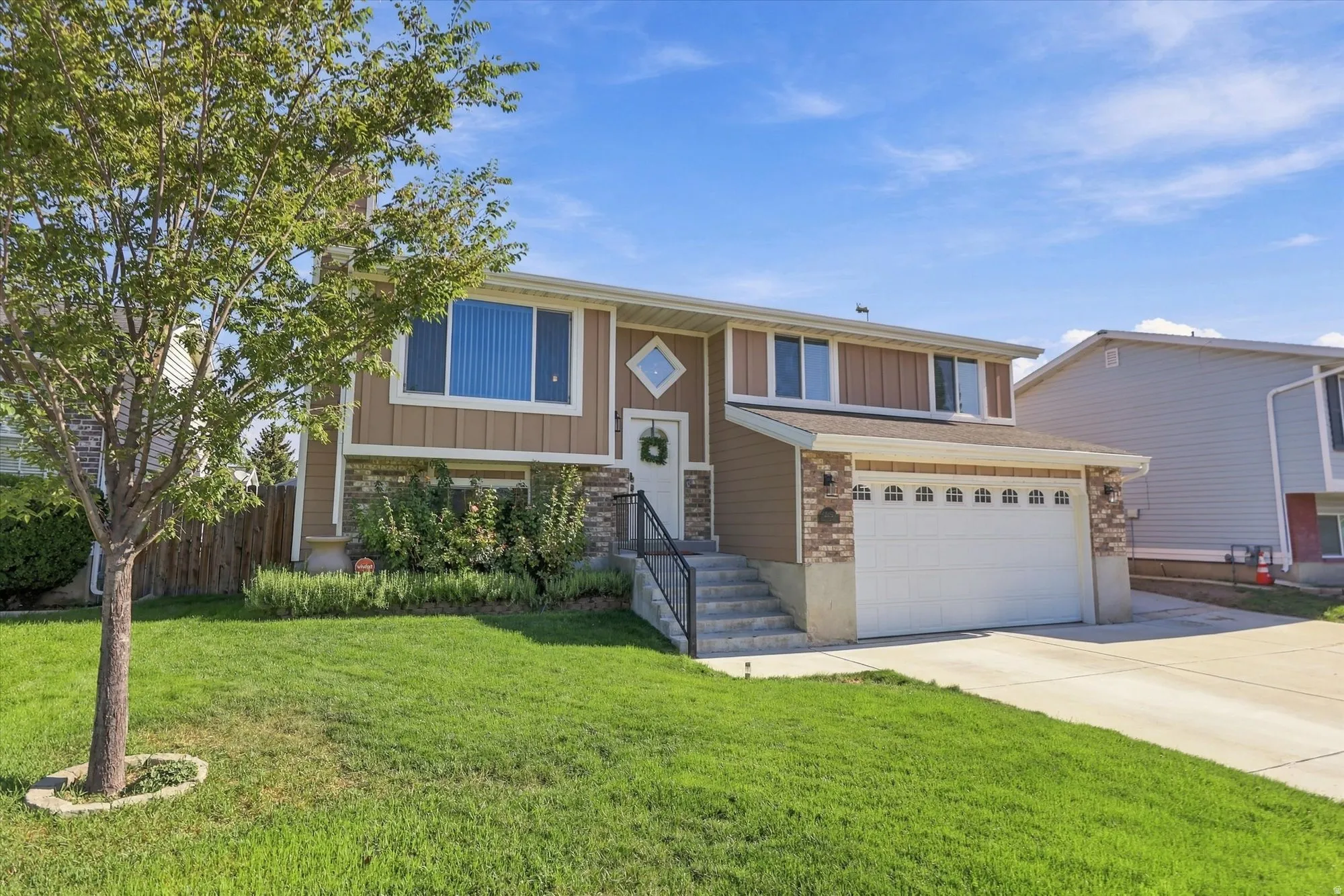 Split-level exterior with a two-car garage, brick accents, and a concrete driveway