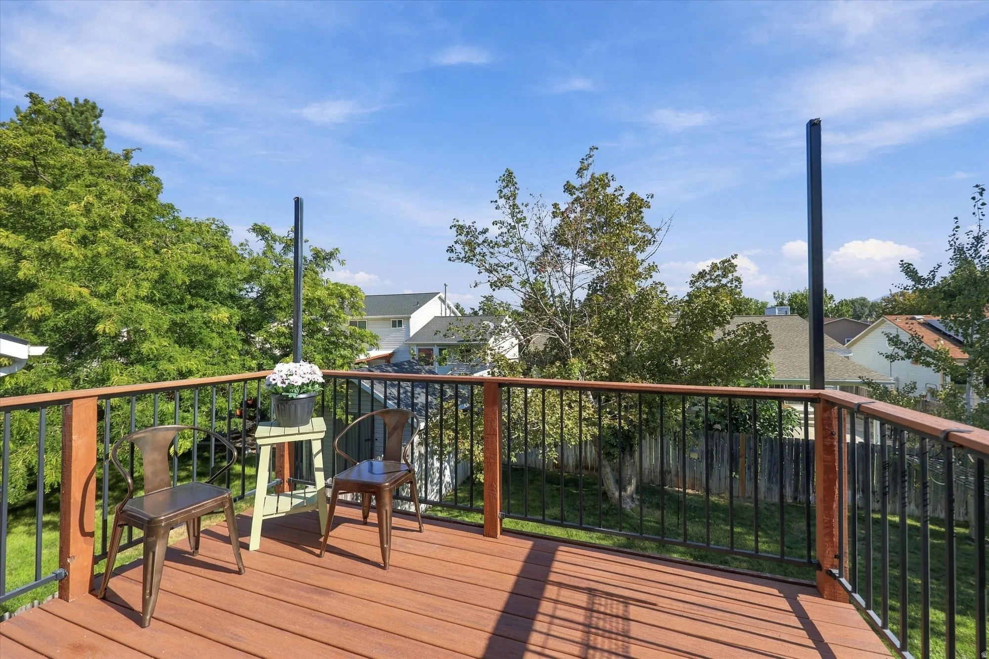 Expansive outdoor deck featuring wood-finish flooring and black metal railings