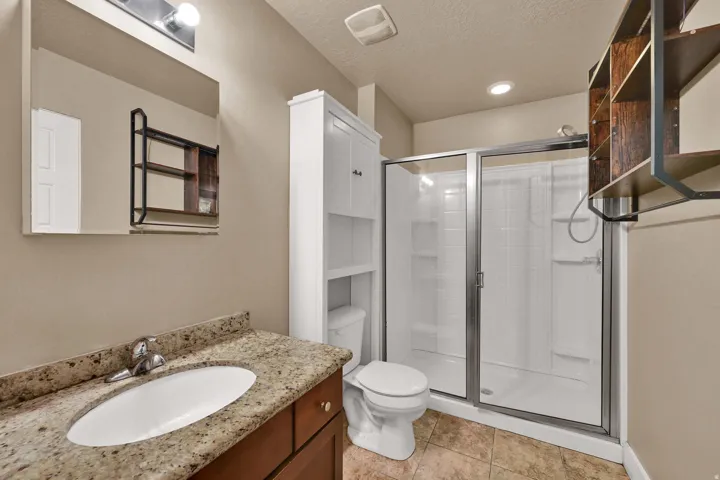 Vanity with granite countertop, integrated sink, and wood-finish cabinetry