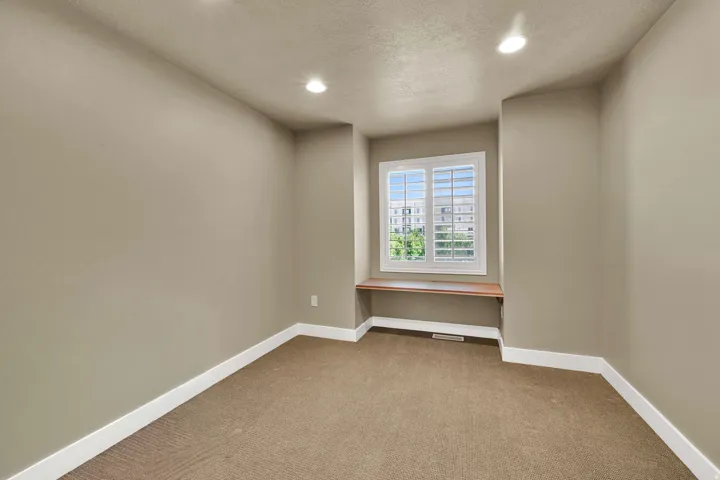 Bedroom #2 with neutral paint and a charming window detail.