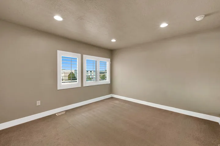Neutral wall paint, recessed lighting, and carpeted flooring