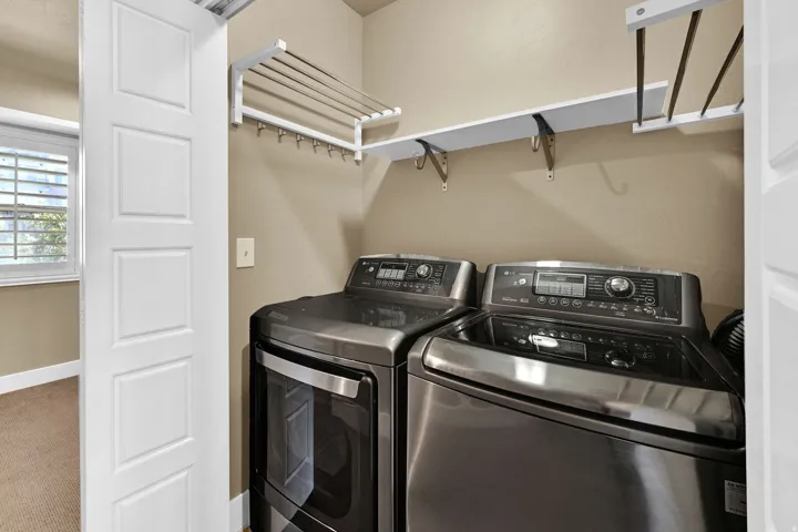 Laundry area featuring a built-in folding rack, a shelf, and neutral wall paint
