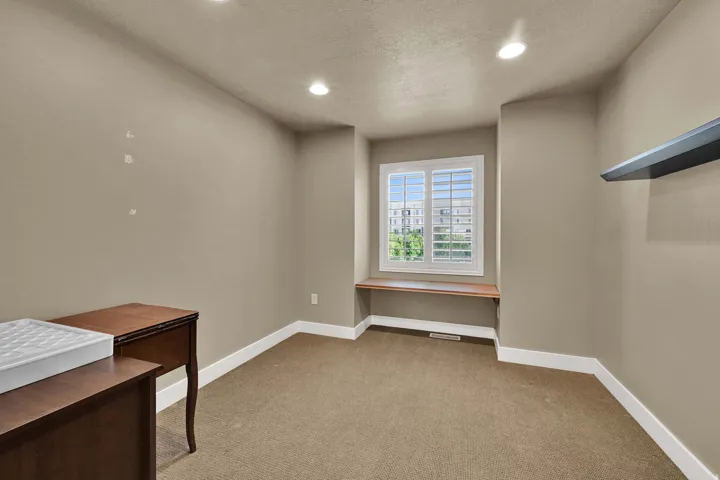 Bedroom #2 with neutral paint and a charming window detail.