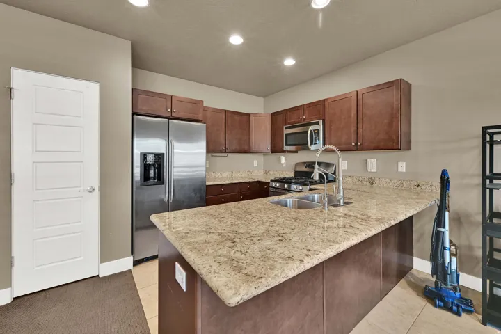 Kitchen with granite and medium wood toned cabinets, barstool seating area as well.