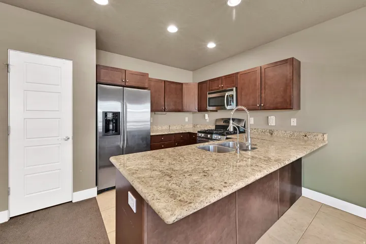 Kitchen with granite and medium wood toned cabinets, barstool seating area as well.