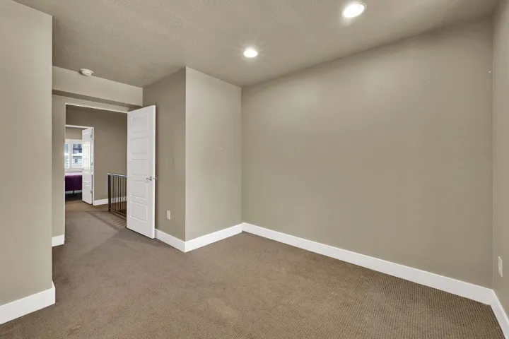 Bedroom #2 with neutral paint and a charming window detail.