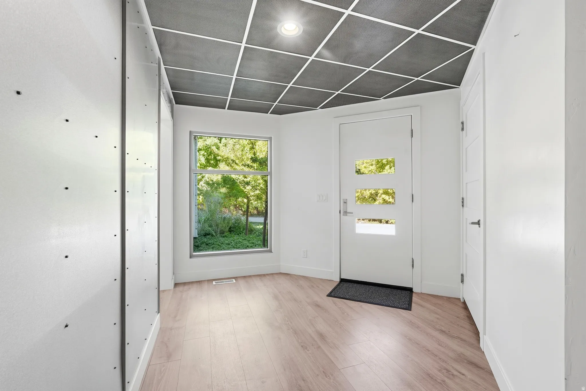 Contemporary entry with a white door featuring three rectangular lites