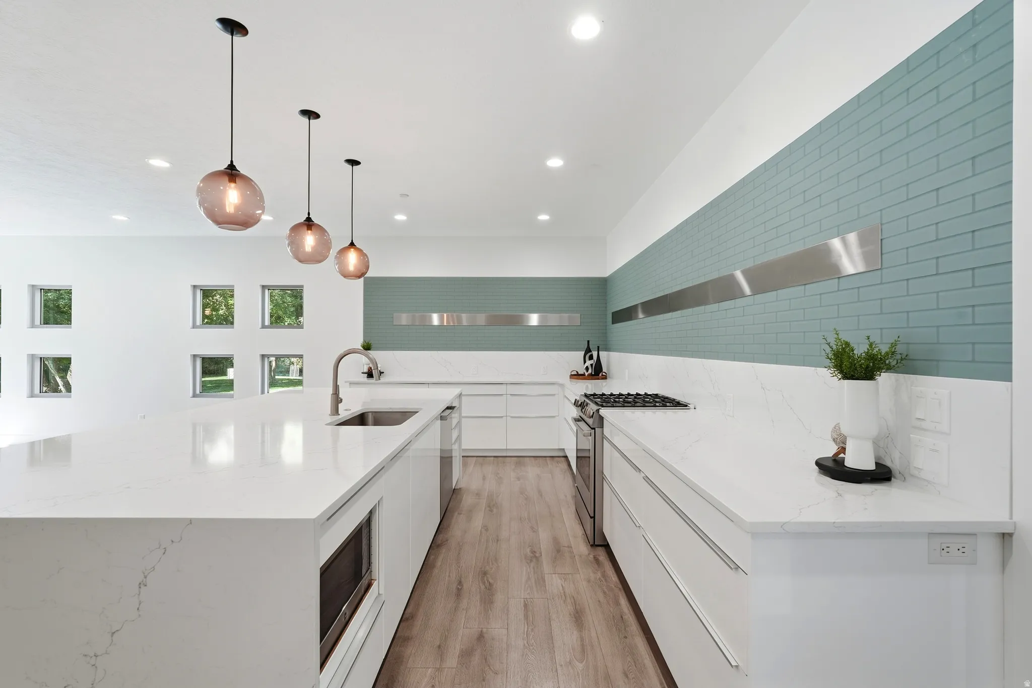 Gourmet kitchen with an expansive island, integrated sink, stainless steel appliances, and a gas cooktop