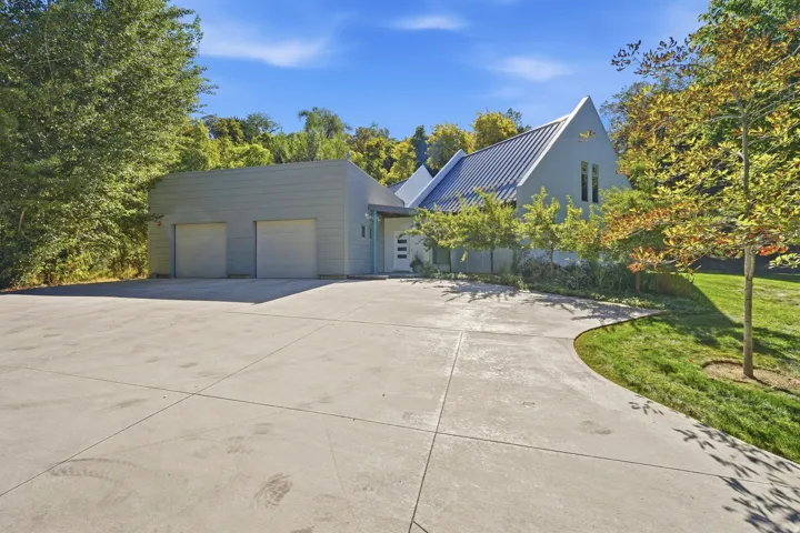Contemporary exterior with a metal roof, a two-car garage, and a concrete driveway