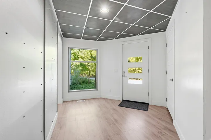 Contemporary entry with a white door featuring three rectangular lites