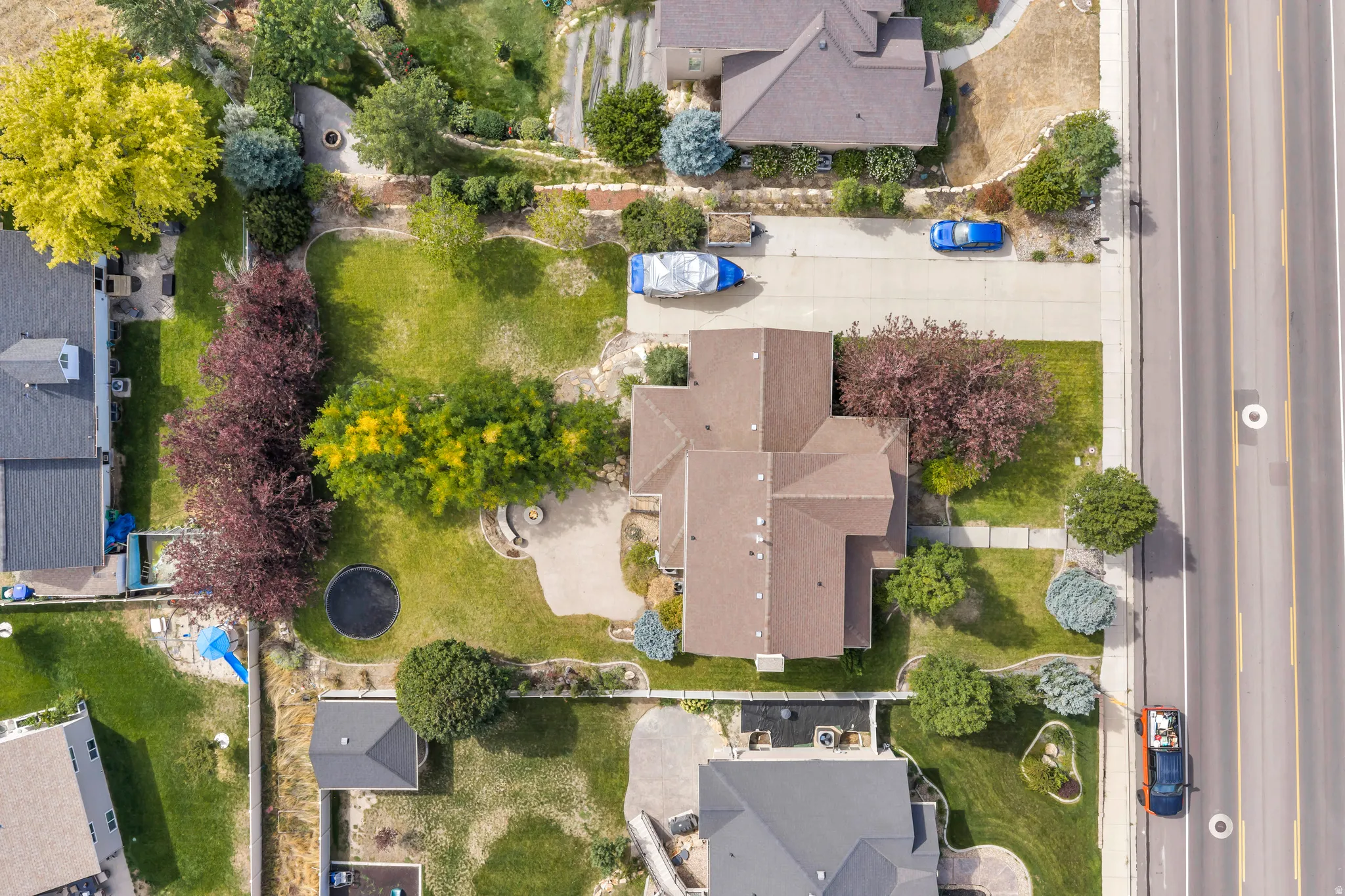 Expansive lot featuring mature trees, manicured lawns, and a private driveway