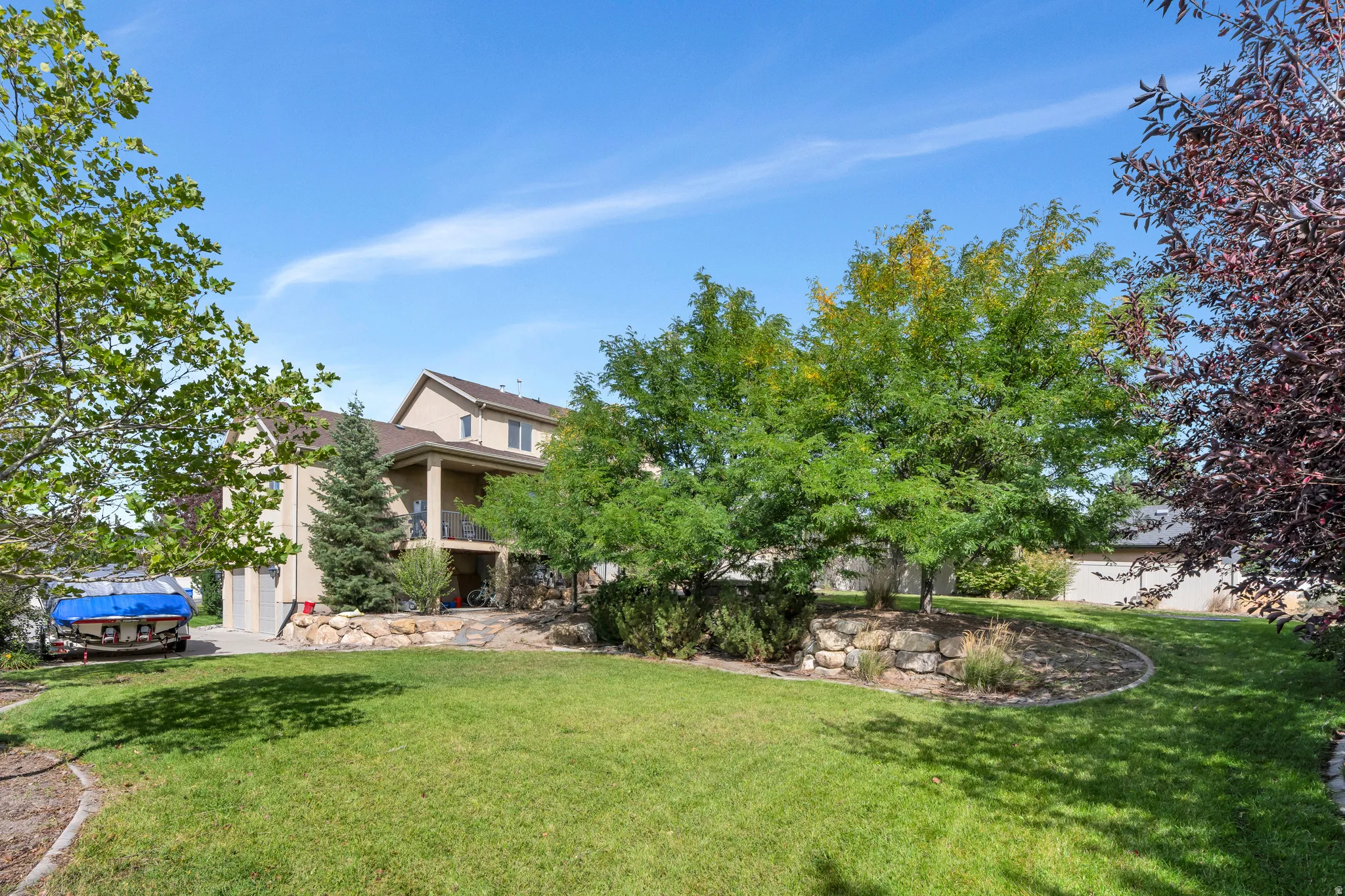 Expansive lawn with mature trees and stone retaining walls