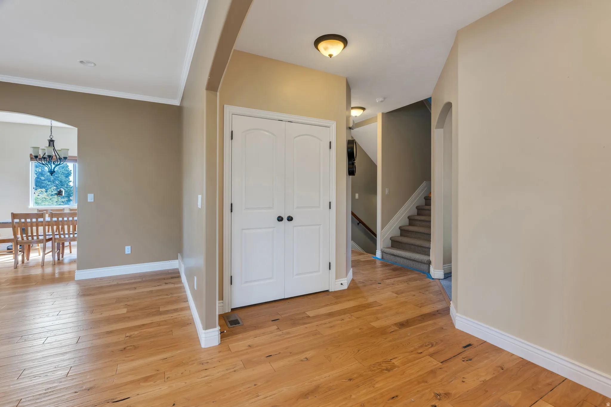 Hardwood flooring, arched doorways, white trim, recessed lighting, and a neutral color palette