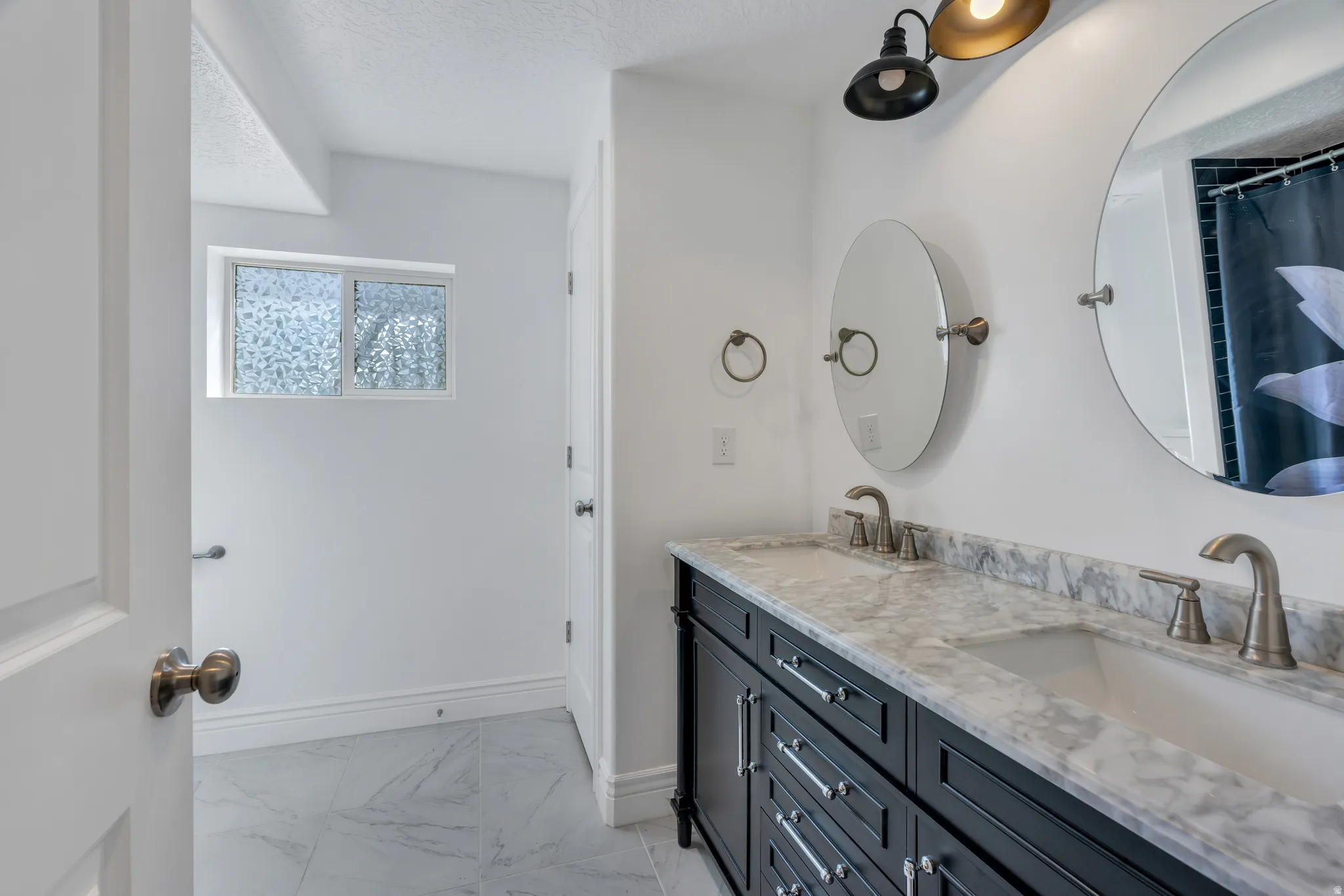 Double vanity with stone countertop, dual undermount sinks, and satin nickel fixtures