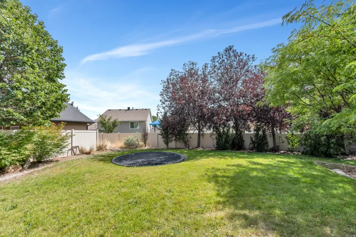 Expansive lawn area with mature trees and perimeter fencing