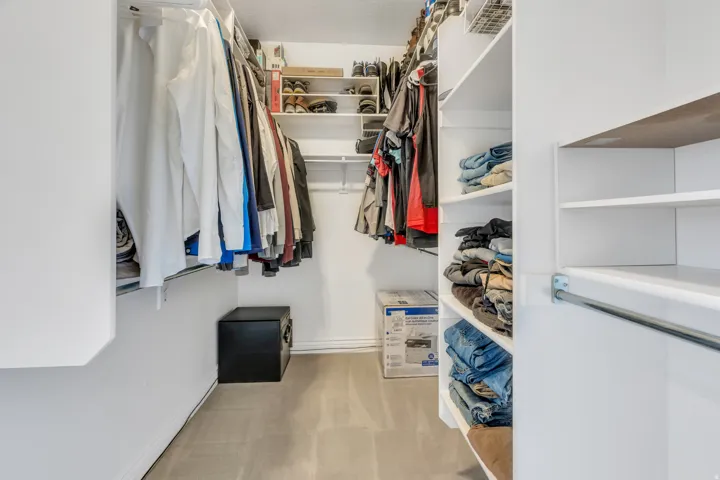Built-in closet shelving and multiple hanging rods provide organizational options