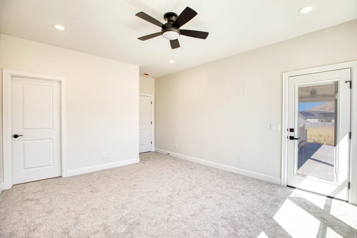 Recessed lighting, ceiling fan with integrated lighting, neutral-toned carpet flooring, white paneled doors, and a glass-paneled exterior door