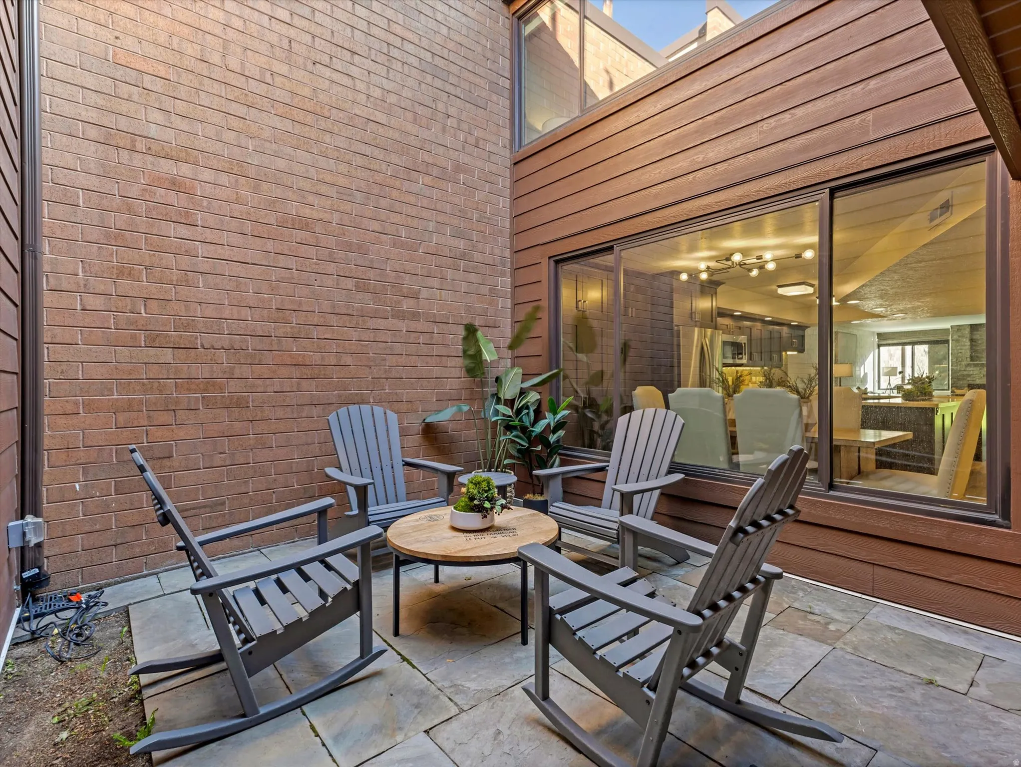 Stone patio featuring a brick exterior wall and wood-paneled siding
