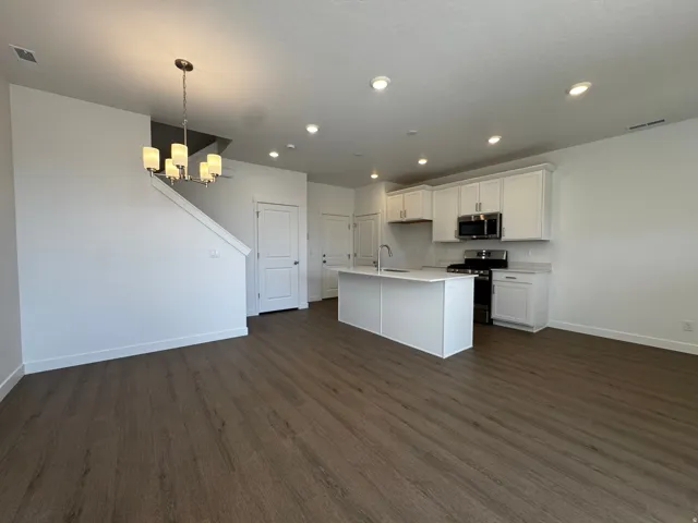 Modern kitchen featuring white cabinetry, stainless steel appliances, a white island, and recessed lighting