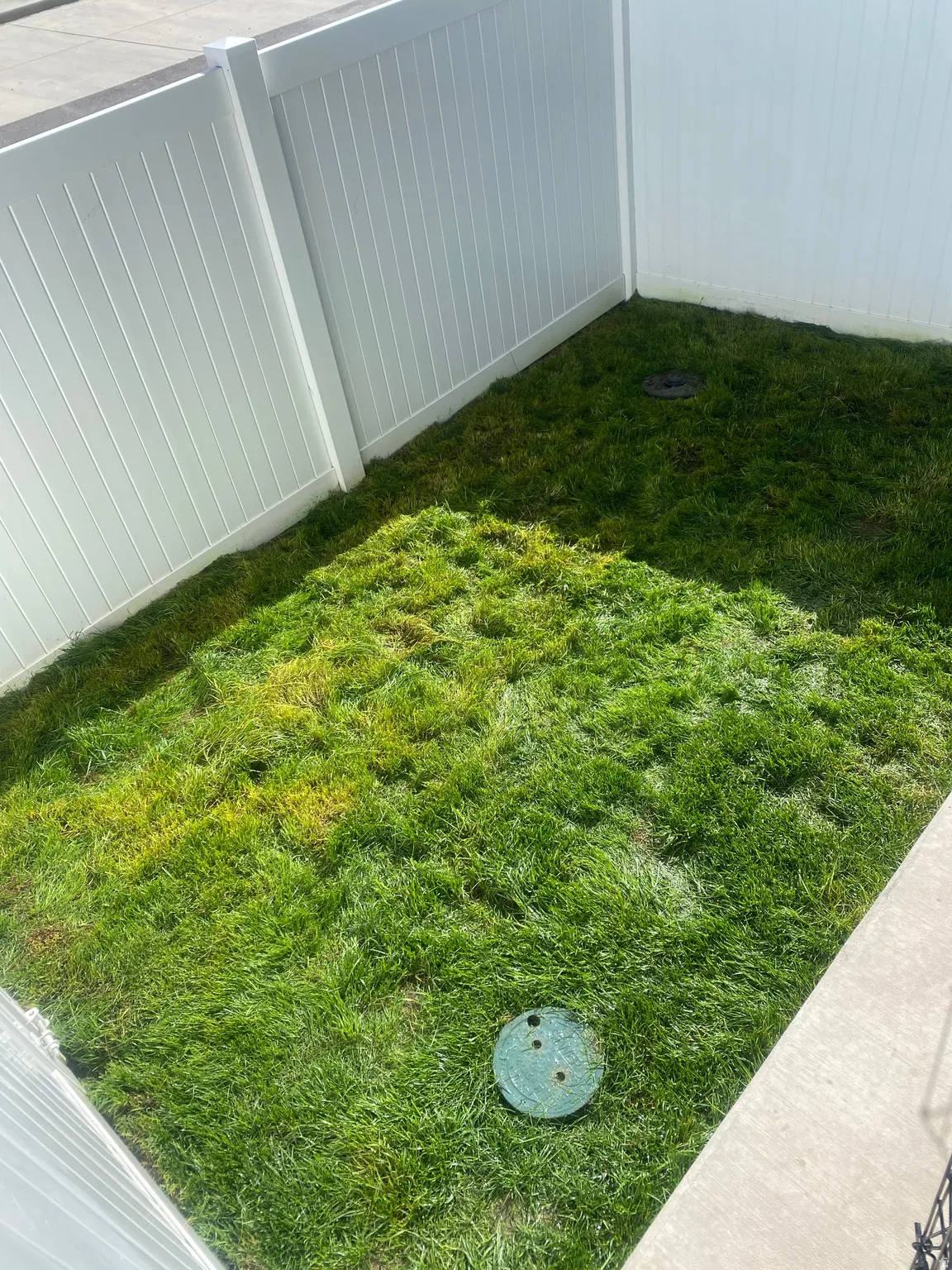 Private yard space featuring a perimeter vinyl fence and green lawn