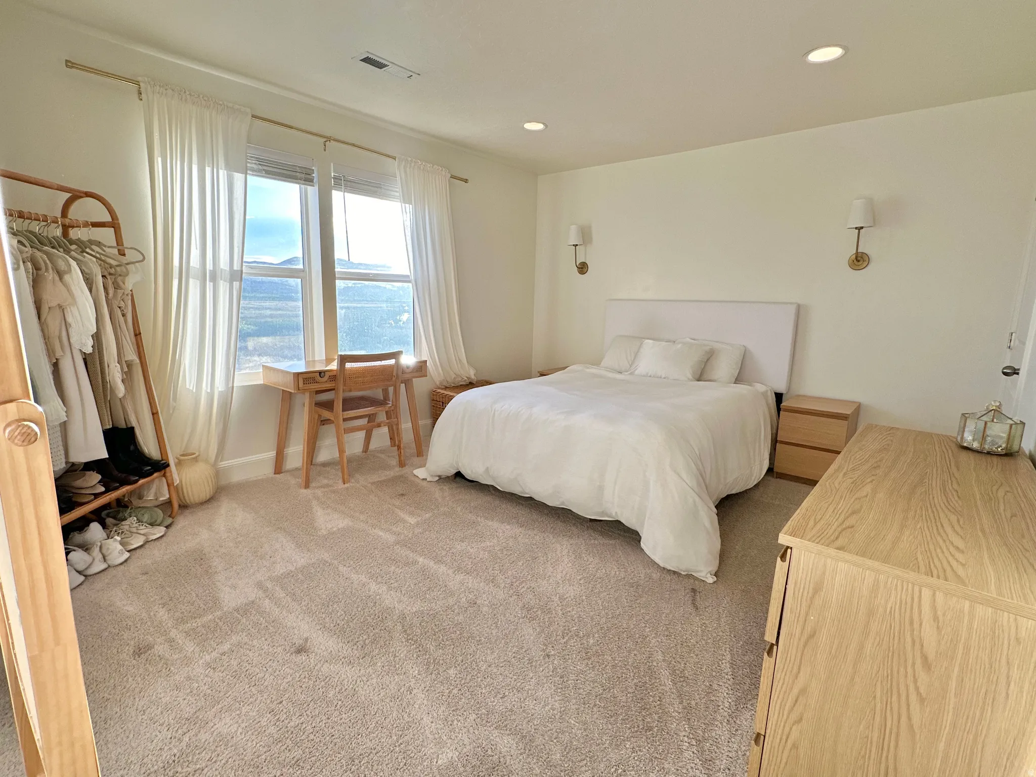 Recessed lighting, wall sconces, wall-to-wall carpeting, and large windows