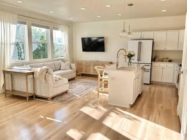 Open-concept living space featuring wood-finish flooring, recessed lighting, and large windows