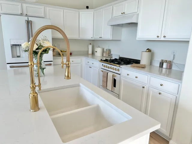 White shaker-style cabinetry with gold-tone hardware