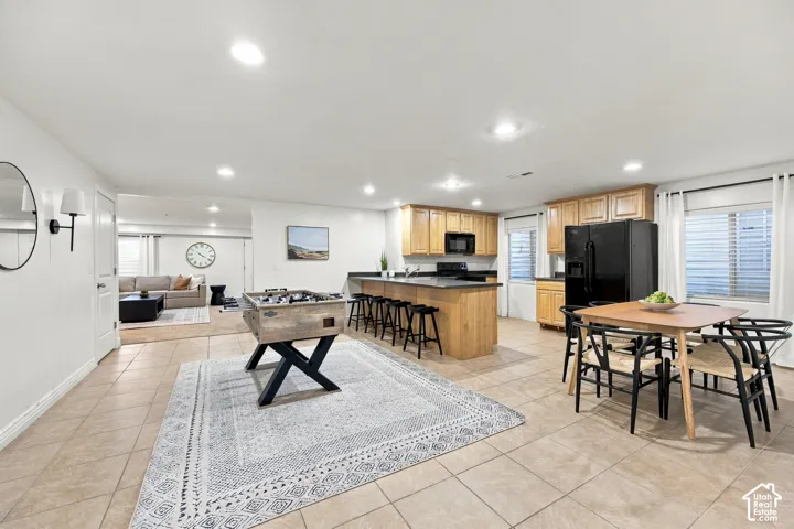 Kitchenette featuring wood cabinetry, dark countertops, and black appliances