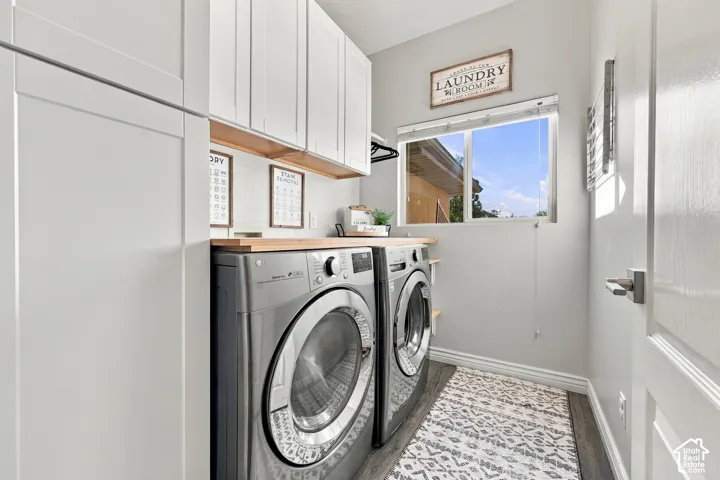 White shaker cabinetry, wood-finish countertop, window with natural light, and wood-finish flooring