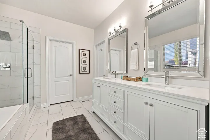 Double vanity with undermount sinks, chrome fixtures, and sconce lighting