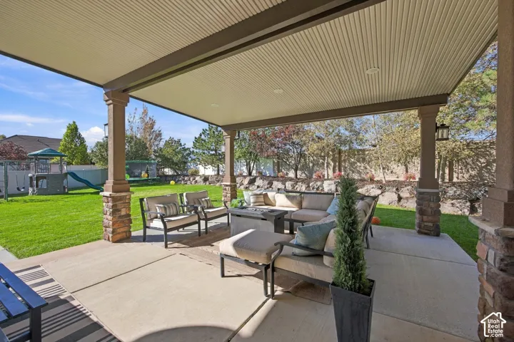 Expansive covered patio with recessed lighting and stone-wrapped pillars
