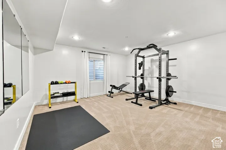 Recessed lighting illuminates the carpeted floor and white walls