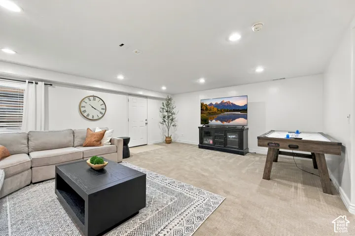 Recessed lighting illuminates this space featuring a carpeted floor, white walls, and a window with blinds