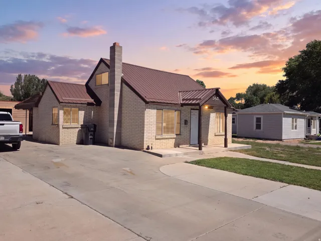 Brick exterior with a brown metal roof, covered front entry, and a concrete driveway