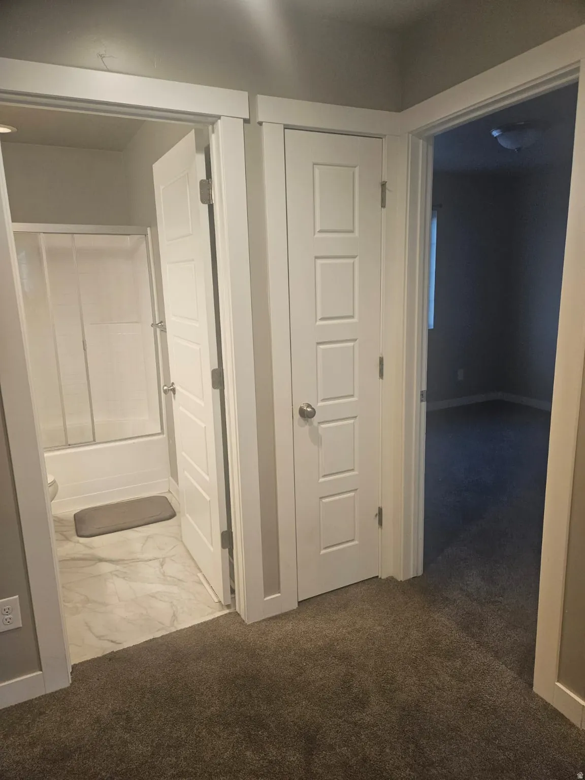 White paneled doors, neutral carpeting, and a full bathroom with a tub and shower combination