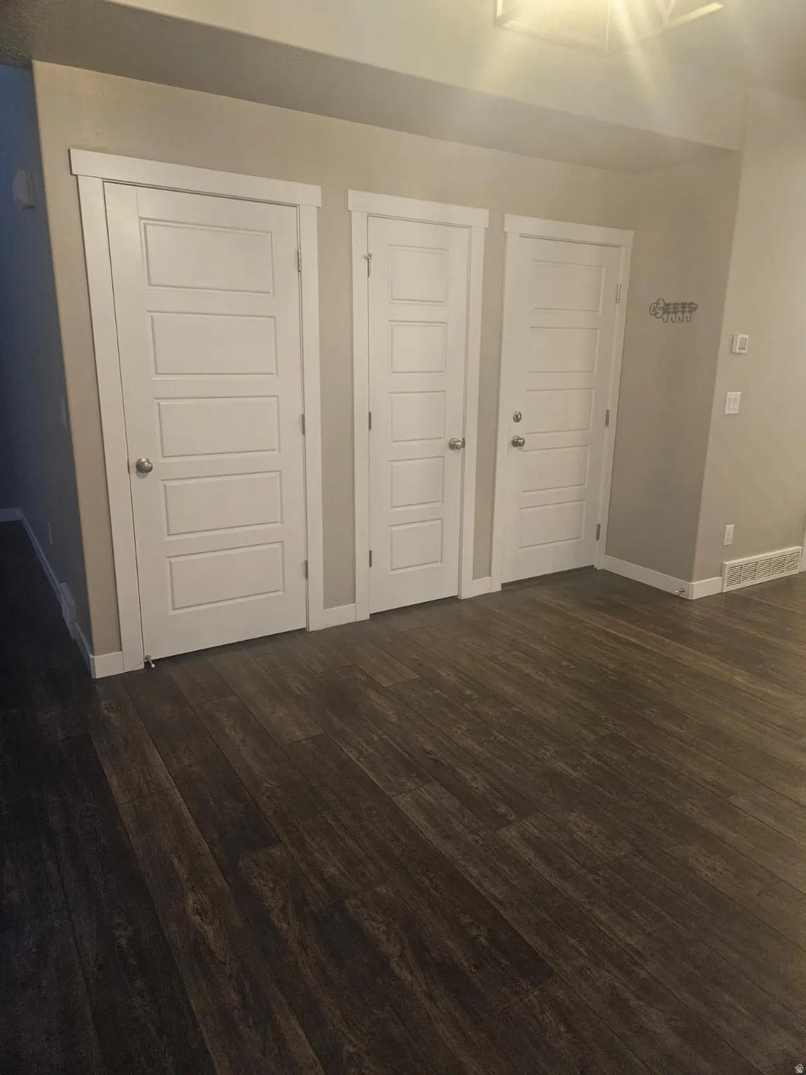 Dark wood-finish flooring with light wall tones and white trim