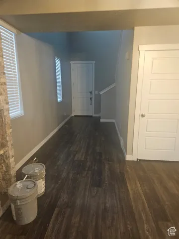 Wood-finish flooring throughout, white trim, and a modern paneled door