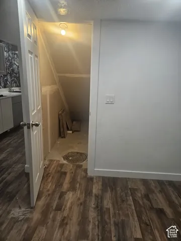 Wood-finish flooring with white wall finishes and a white panel door